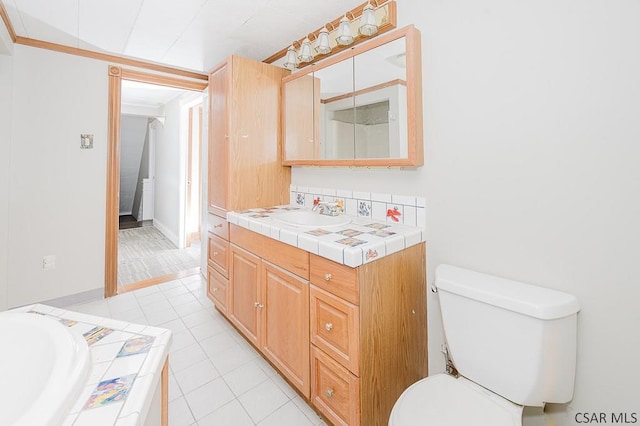 bathroom with toilet, tile patterned floors, a bath, and vanity