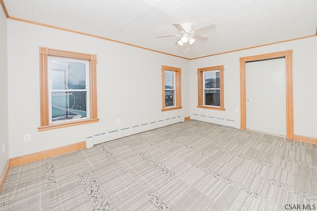 spare room featuring ceiling fan, ornamental molding, a baseboard radiator, and baseboards