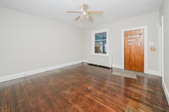 empty room with radiator, ceiling fan, baseboards, and hardwood / wood-style flooring