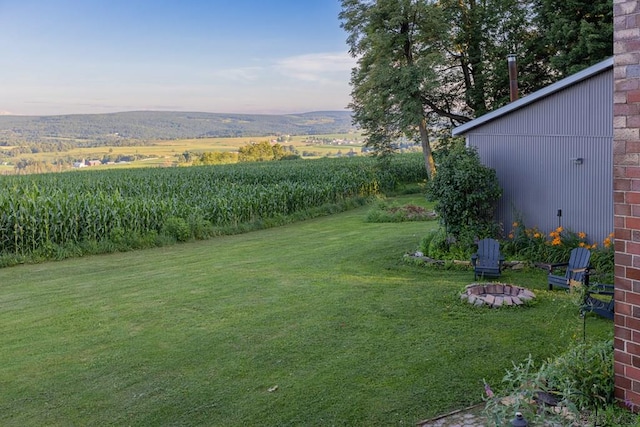 view of yard featuring an outdoor fire pit and a rural view