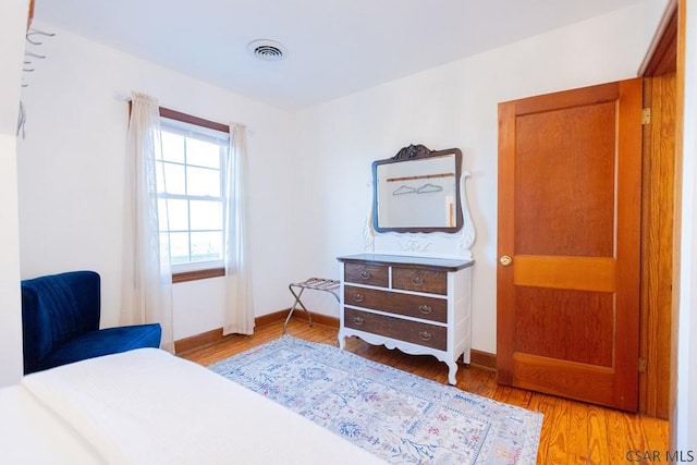 bedroom with baseboards, visible vents, and light wood-style flooring