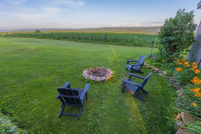 view of yard featuring an outdoor fire pit and a rural view
