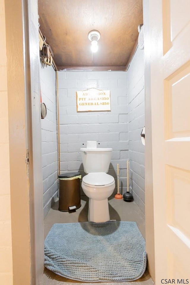bathroom with toilet and unfinished concrete flooring