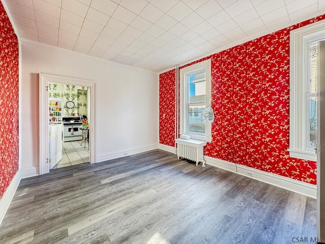 521 N Julian St, Ebensburg, PA 15931 - empty room with wallpapered walls, radiator heating unit, wood finished floors, and ornamental molding