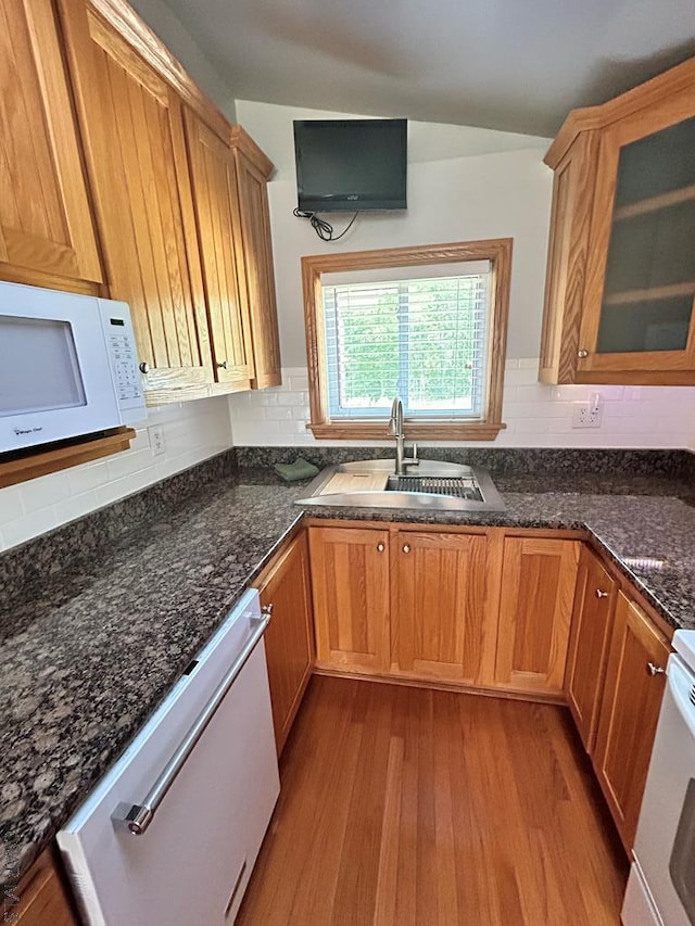 kitchen with sink, range, light hardwood / wood-style flooring, dishwasher, and dark stone counters