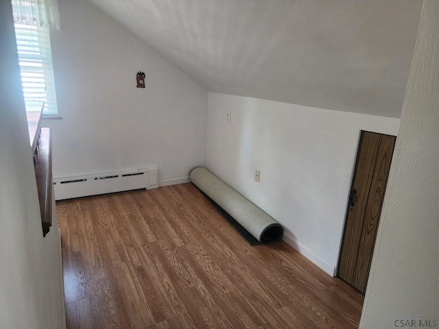 bonus room featuring lofted ceiling, a baseboard heating unit, and wood-type flooring