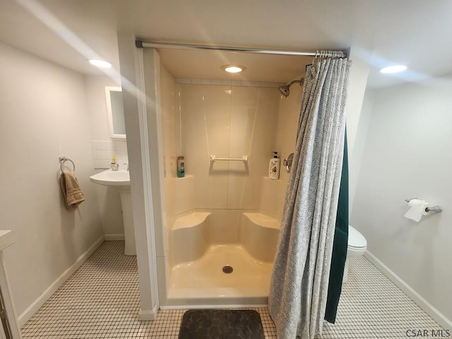 bathroom featuring a shower with curtain, tile patterned floors, toilet, and tasteful backsplash