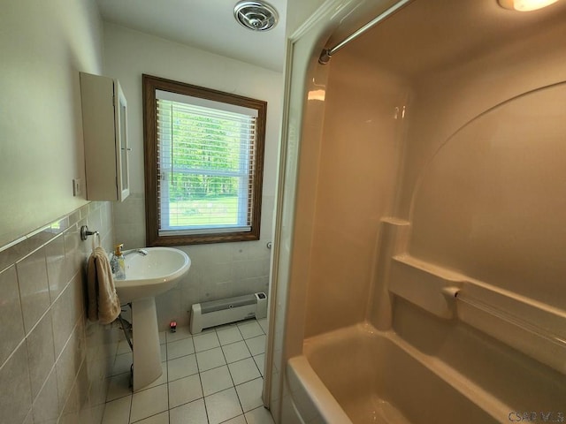 bathroom with tile walls, tile patterned floors, washtub / shower combination, and baseboard heating