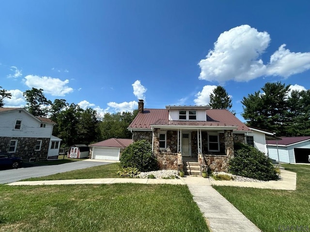 view of front of property featuring a garage, an outdoor structure, a front lawn, and a porch