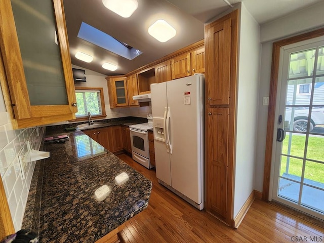 kitchen with hardwood / wood-style flooring, sink, white appliances, and decorative backsplash