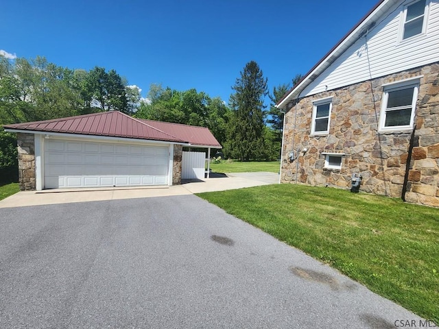 view of side of property with a garage, an outdoor structure, and a yard