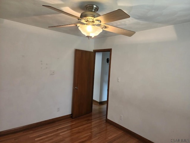 spare room with dark hardwood / wood-style floors and ceiling fan