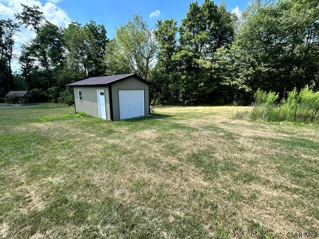 view of yard featuring a garage and an outdoor structure