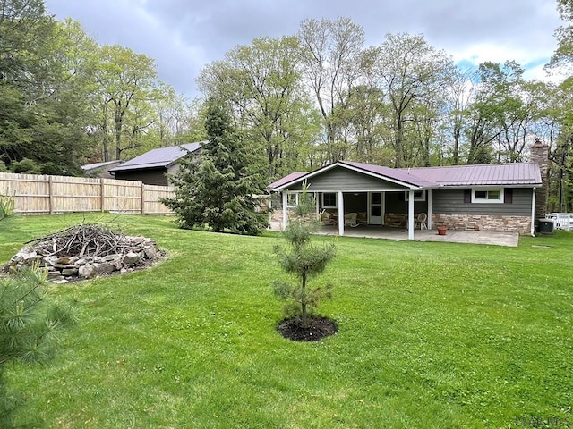 643 Laurel Summit Rd, Boswell, PA 15531 - rear view of house featuring stone siding, a patio area, an outdoor fire pit, a chimney, and metal roof