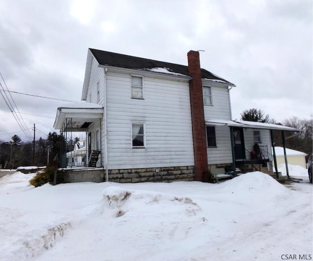 snow covered property featuring a porch