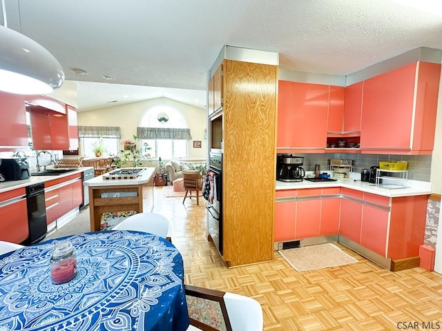 kitchen featuring appliances with stainless steel finishes, lofted ceiling, sink, light parquet floors, and a textured ceiling