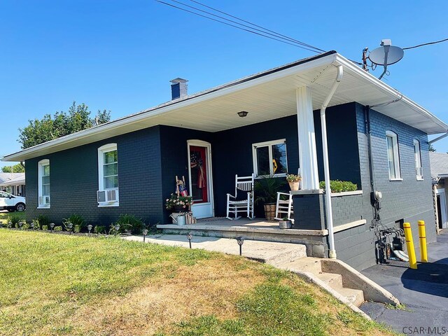 view of front of property featuring covered porch and a front yard