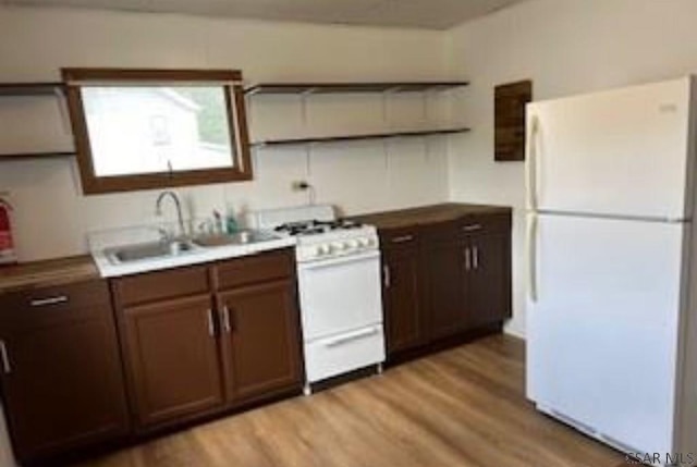 kitchen featuring white appliances, sink, and light hardwood / wood-style flooring