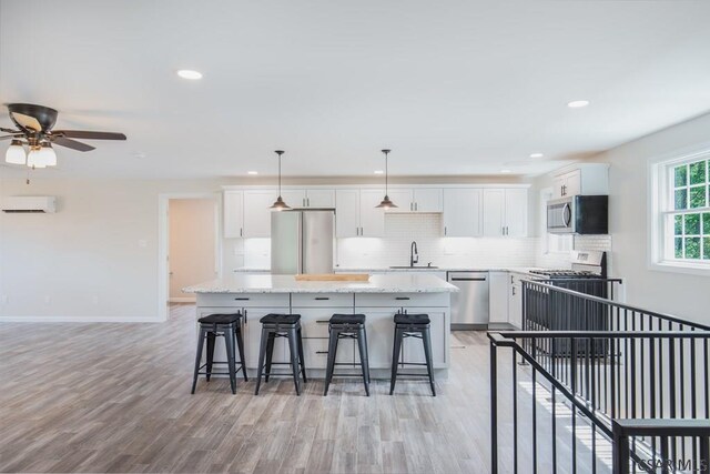 kitchen featuring stainless steel appliances, white cabinetry, and a kitchen island