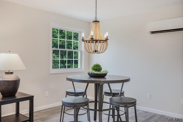 dining room featuring wood-type flooring, an inviting chandelier, and a wall unit AC