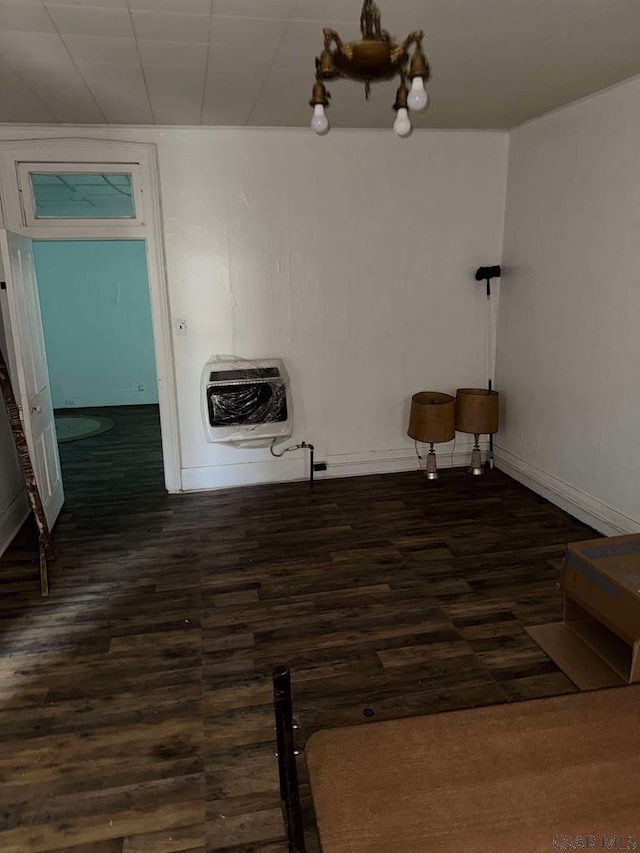 unfurnished dining area featuring dark wood-style floors, baseboards, and heating unit