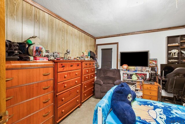 carpeted bedroom featuring ornamental molding, a textured ceiling, and wood walls