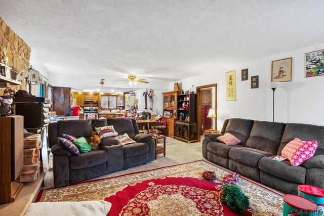 living room with ceiling fan and a textured ceiling