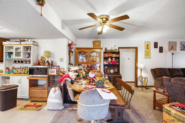 dining space featuring ceiling fan, a textured ceiling, and light tile patterned floors