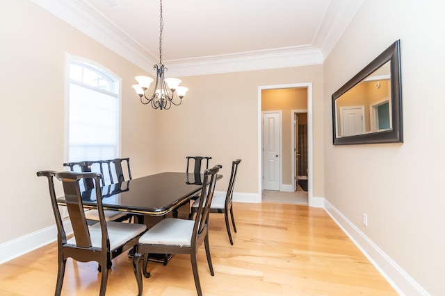 dining space with light wood-type flooring, crown molding, and a chandelier