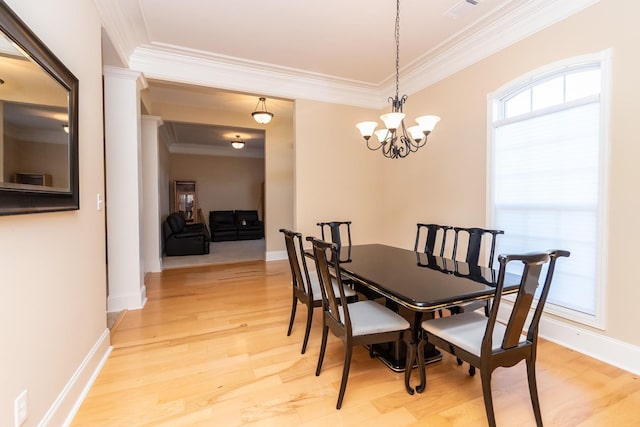 dining room featuring an inviting chandelier, crown molding, and light wood-type flooring