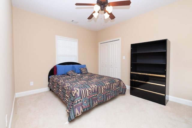 bedroom with a closet, ceiling fan, and light colored carpet