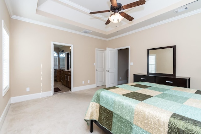 carpeted bedroom with ensuite bath, a raised ceiling, ornamental molding, and ceiling fan