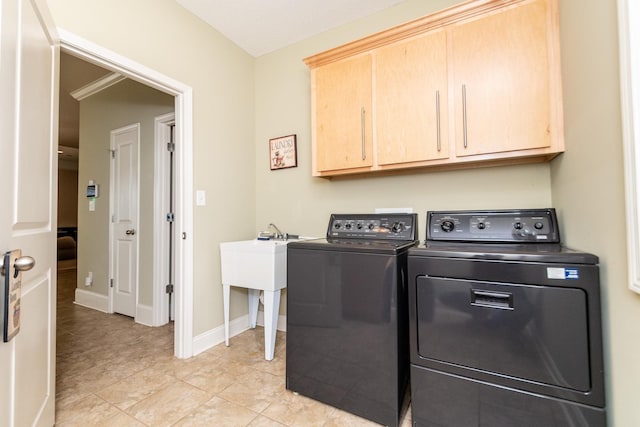 laundry room with light tile flooring, cabinets, and washer and clothes dryer