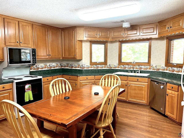 2382 Gallimore Mill Rd, Jeffersonville, GA 31044 - kitchen featuring black microwave, stainless steel dishwasher, electric range, a textured ceiling, and light wood-style floors
