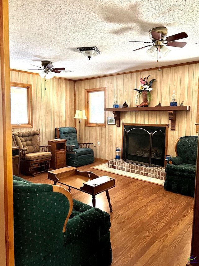 2382 Gallimore Mill Rd, Jeffersonville, GA 31044 - living area featuring a ceiling fan, a textured ceiling, wood finished floors, a fireplace, and wood walls