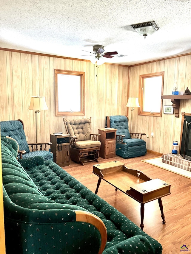 2382 Gallimore Mill Rd, Jeffersonville, GA 31044 - living room with healthy amount of natural light, wood walls, wood finished floors, a ceiling fan, and a textured ceiling