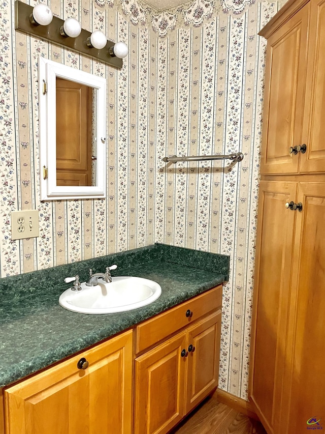 2382 Gallimore Mill Rd, Jeffersonville, GA 31044 - bathroom featuring vanity, wallpapered walls, and wood finished floors