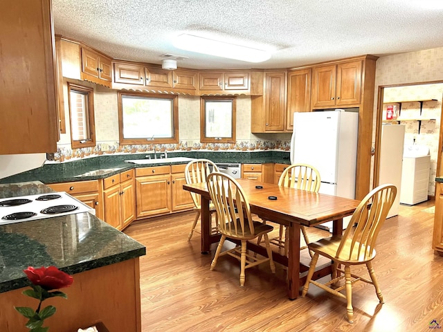 2382 Gallimore Mill Rd, Jeffersonville, GA 31044 - kitchen with washer / clothes dryer, white appliances, light wood-style floors, a textured ceiling, and brown cabinets