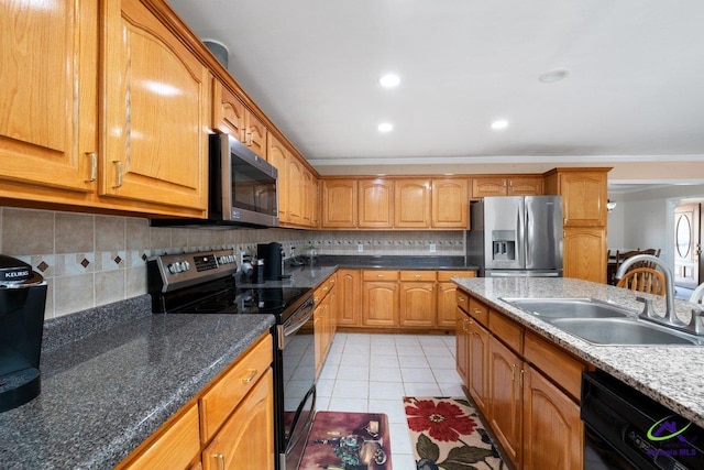 kitchen featuring dark stone counters, black appliances, sink, light tile patterned floors, and ornamental molding