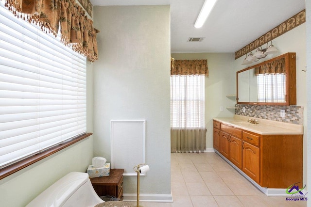 bathroom with decorative backsplash, vanity, and tile patterned floors