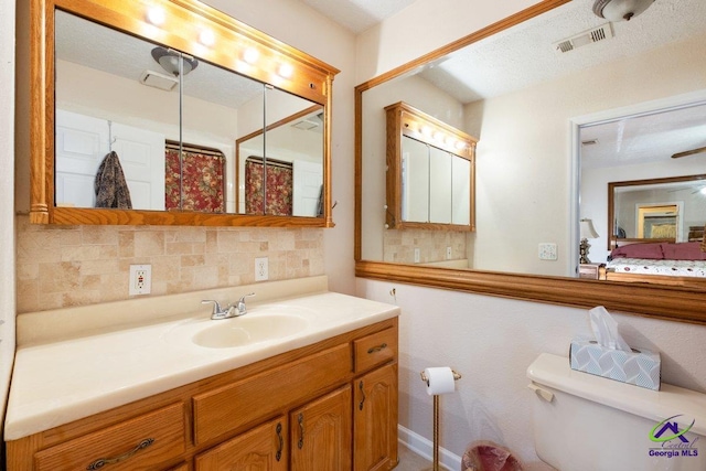 bathroom with tasteful backsplash, walk in shower, vanity, and toilet