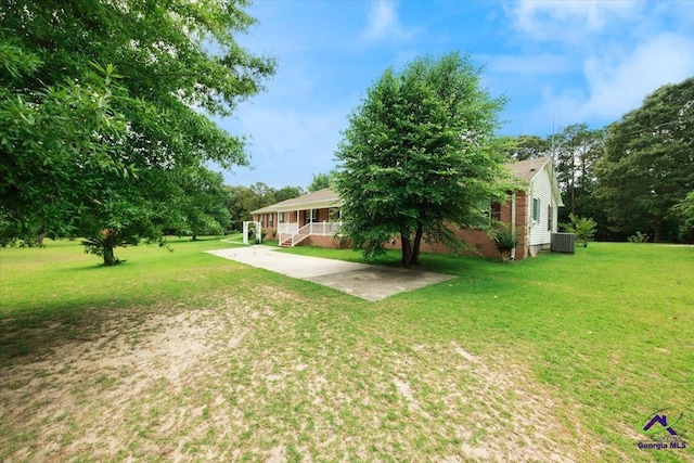 view of yard featuring central AC and covered porch