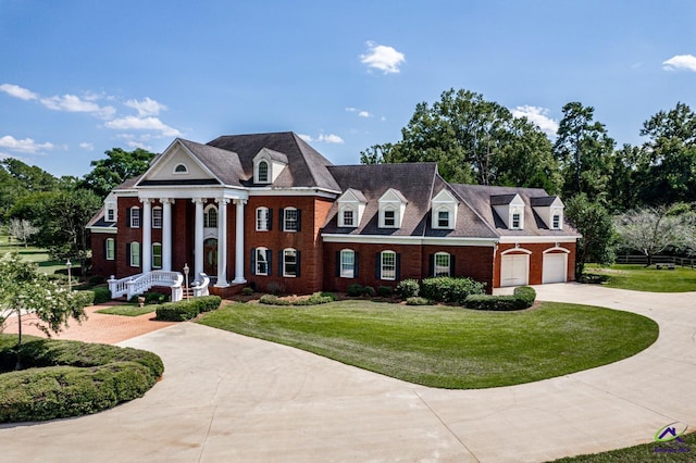 neoclassical / greek revival house with a garage and a front lawn