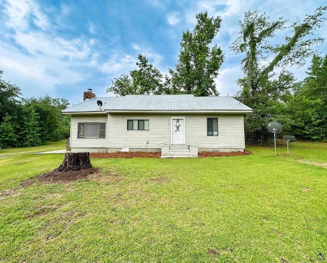 rear view of property featuring a lawn