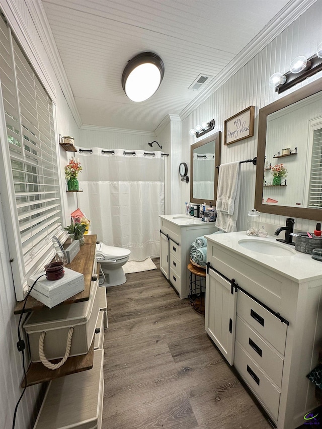 bathroom with crown molding, hardwood / wood-style floors, toilet, and dual bowl vanity