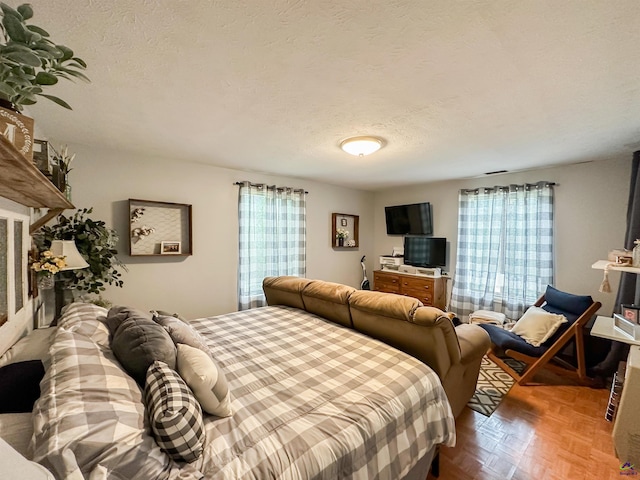 bedroom featuring a textured ceiling, parquet floors, and multiple windows