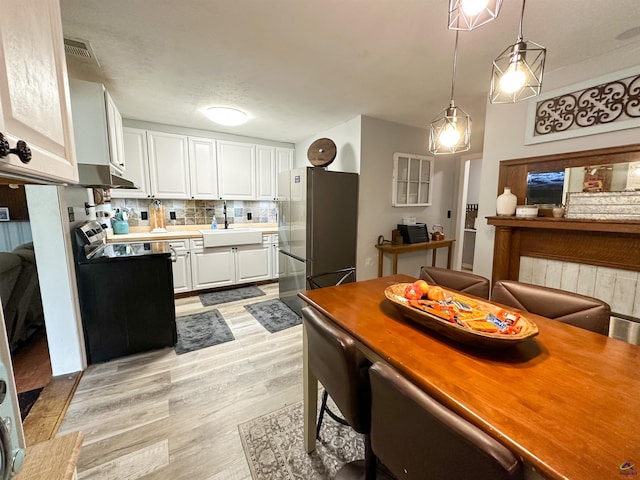 dining space featuring light wood-type flooring and sink