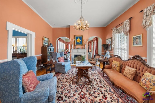 living room with crown molding, a chandelier, and wood-type flooring