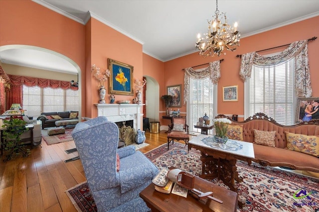 interior space featuring crown molding, a fireplace, a chandelier, and light wood-type flooring