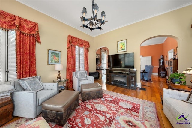 living room with crown molding, hardwood / wood-style floors, and a chandelier